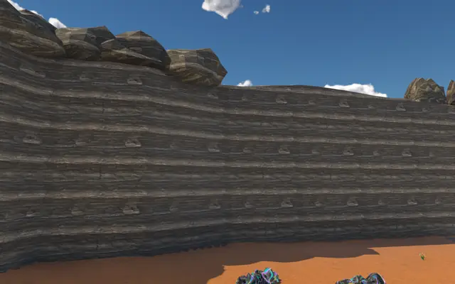 A banded cliff wall seen from the ground inside a region